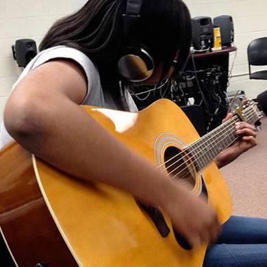 student playing a guitar