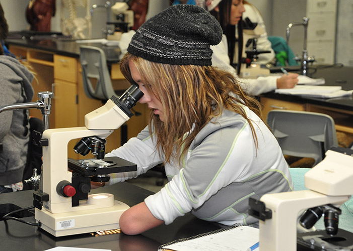 Histologic Technician students studying slide in microscope
