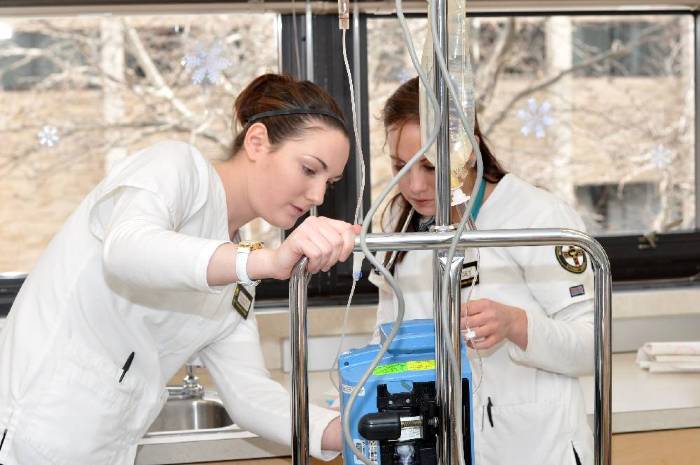 Nursing Students adjusting IV in nursing lab