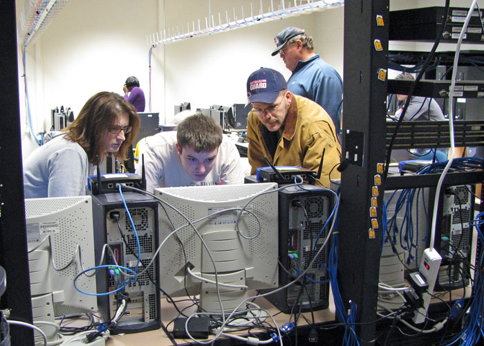 students setting up a computer network running cable