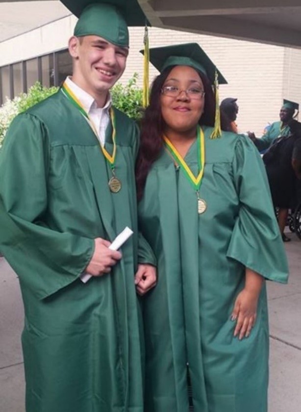 two high school graduates posing for photo